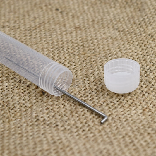 One needle felting needle in a white plastic tube on a hessian mat with a lid